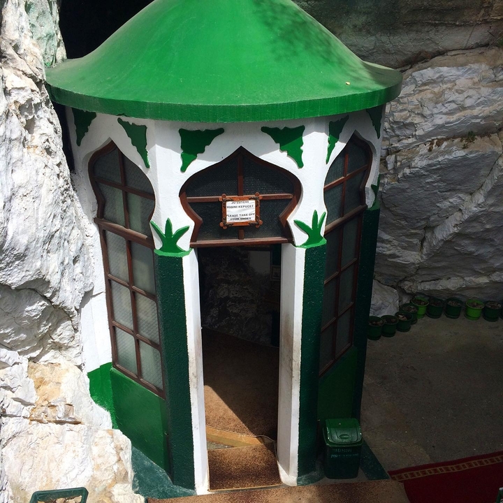 Extérieur d'une petite structure en pierre décorée.