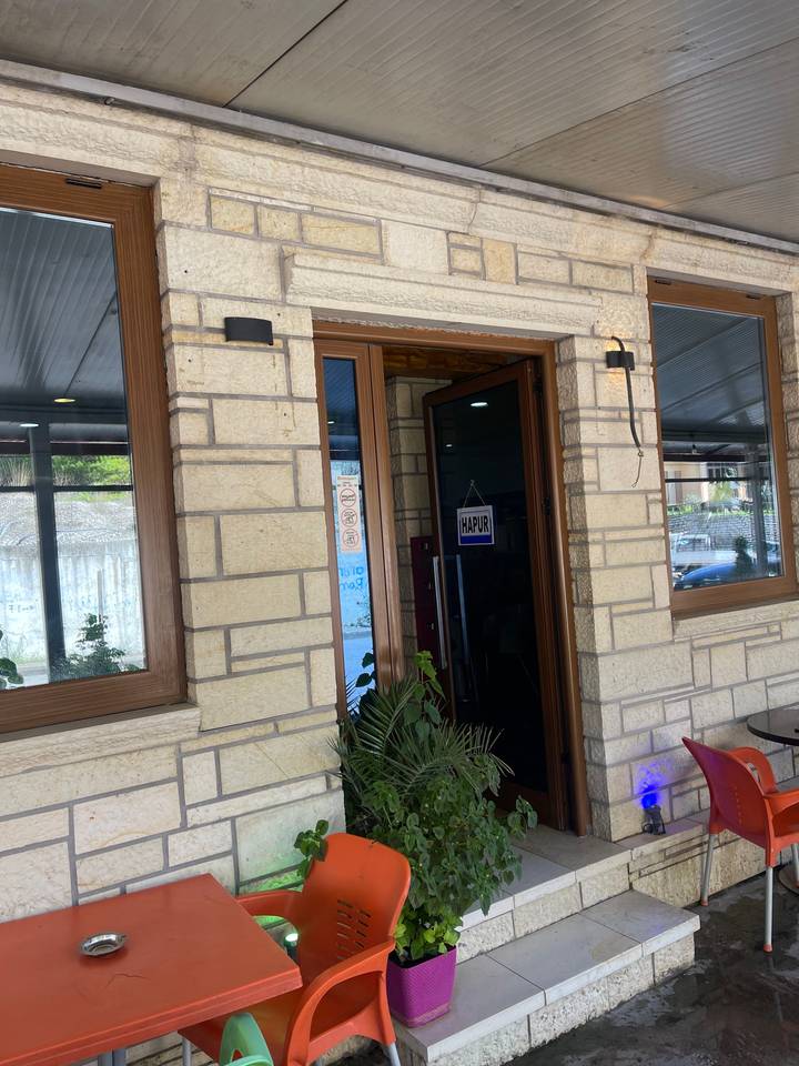 Entrée d'un bâtiment avec des panneaux et des plantes en pot.