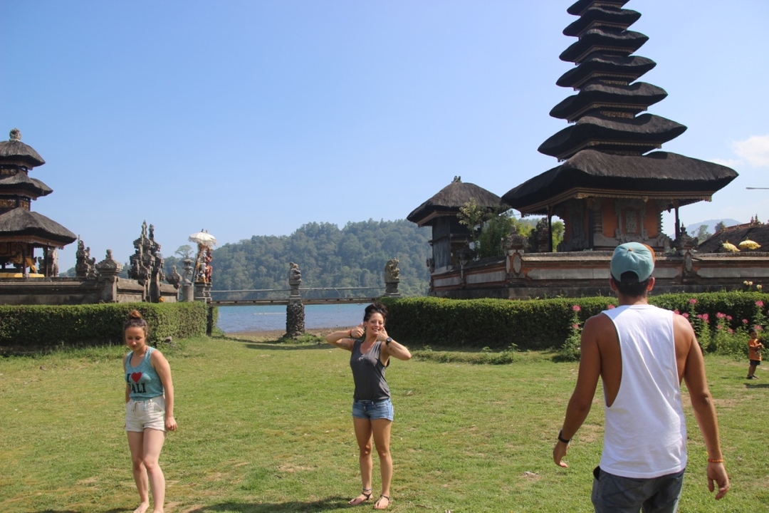 Three young people near a traditional Balinese temple.