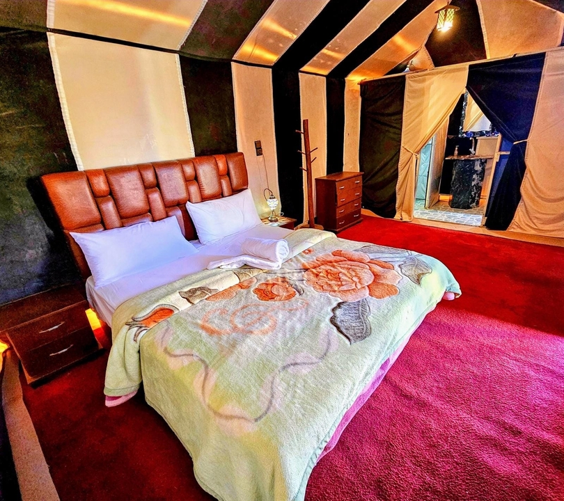 Une chambre d'hôtel avec une couverture colorée sur le lit.