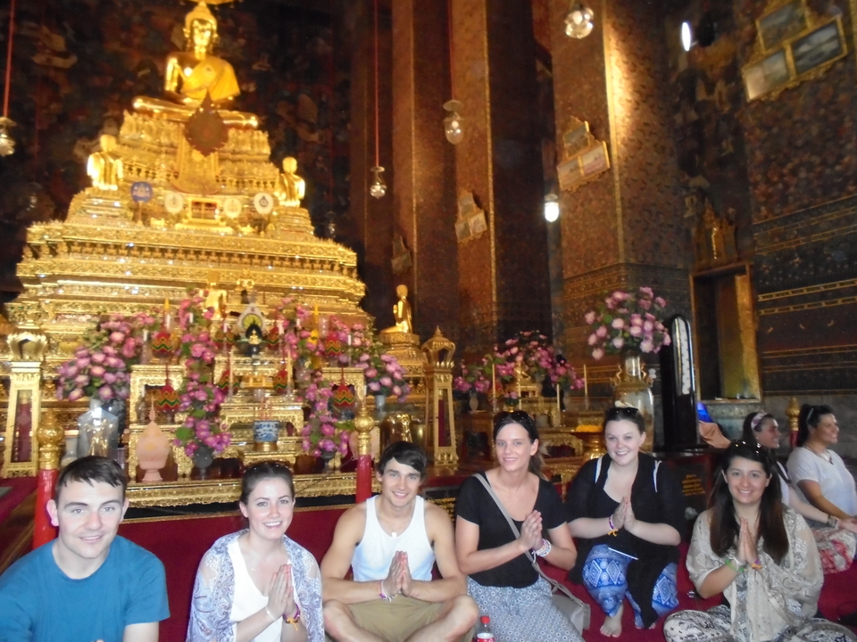 People posing in front of an ornate golden altar.