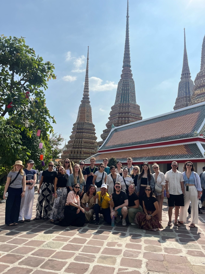 Grand groupe posant devant un temple avec des pagodes.