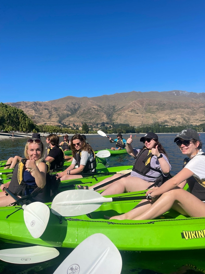 Des gens faisant du kayak sur un lac paisible avec des montagnes.