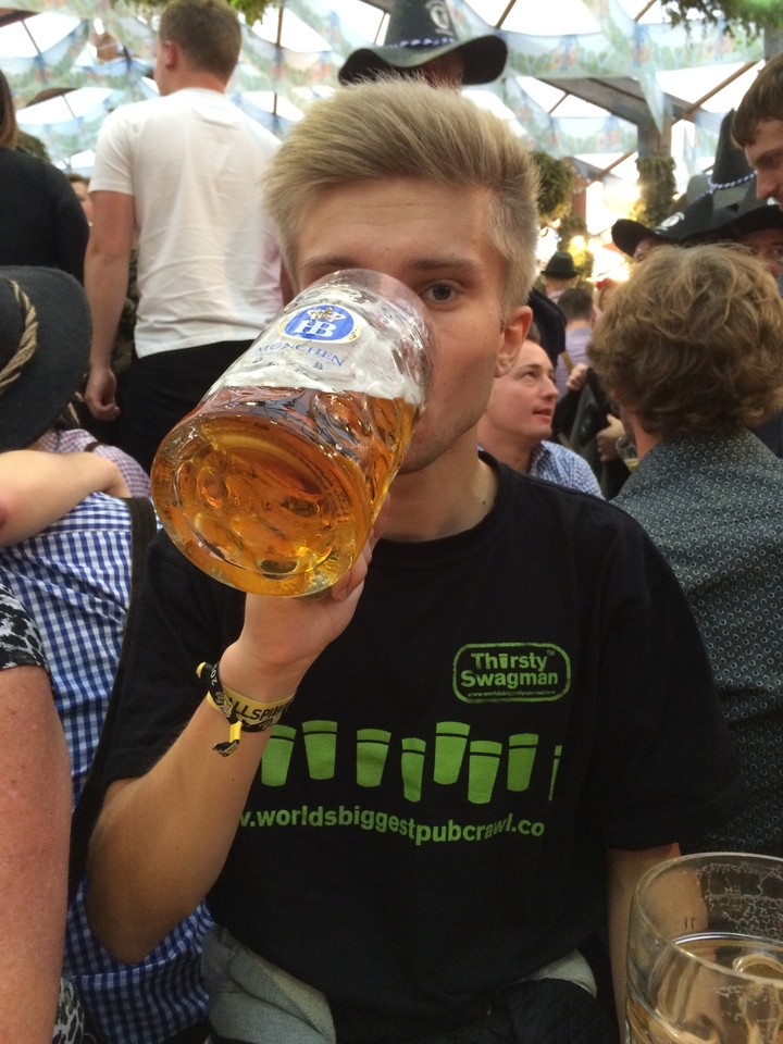 Personne buvant dans un grand verre de bière lors d'un événement festif.