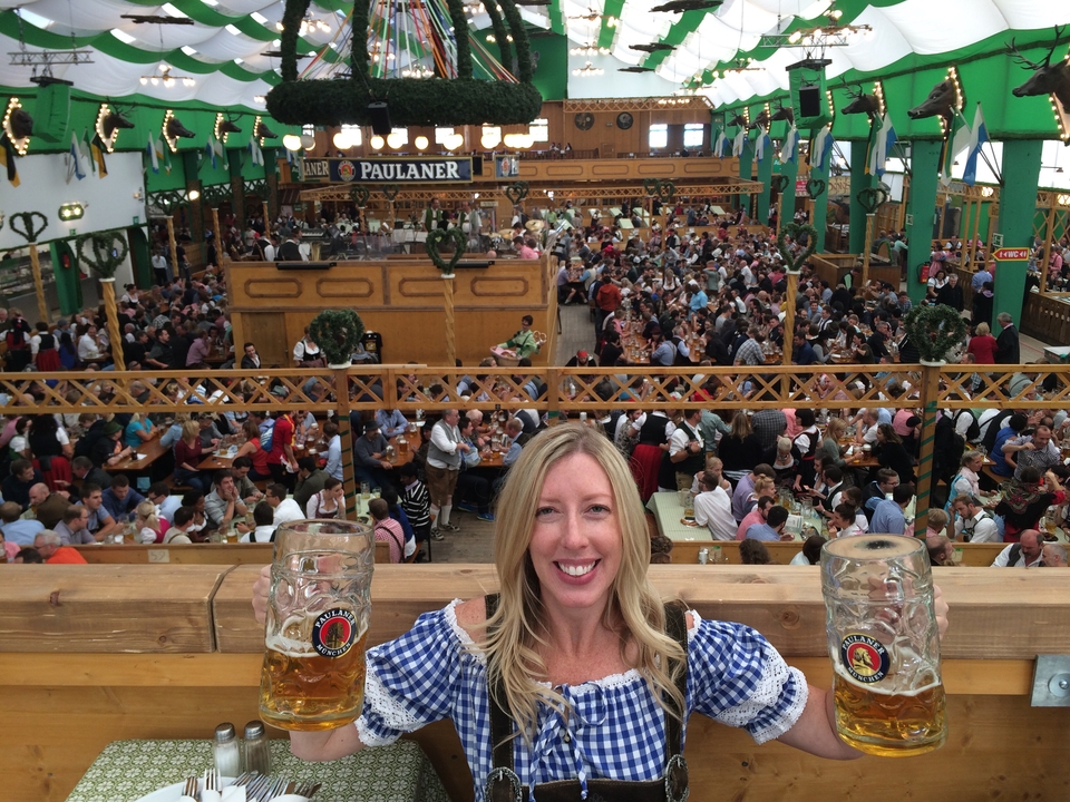 Femme posant lors d'une fête de la bière avec des verres de bière.