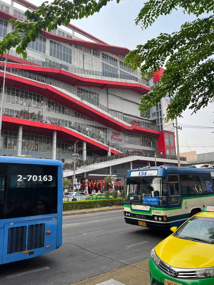 Rue animée dans une ville avec une gare routière moderne.