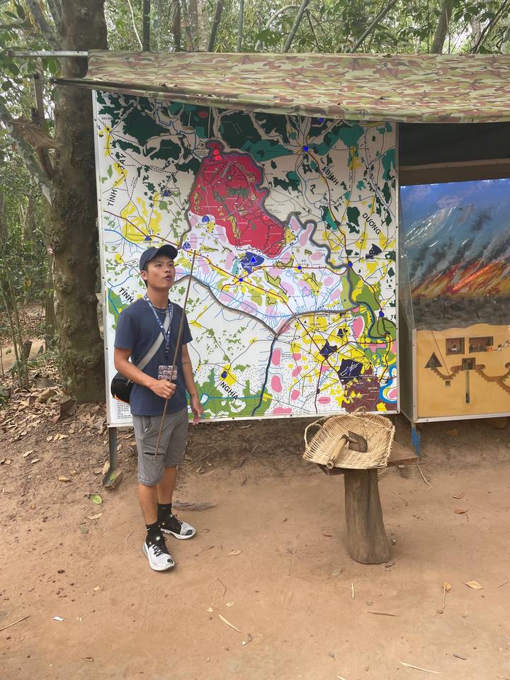 Un homme debout devant un affichage de carte colorée à l'extérieur.