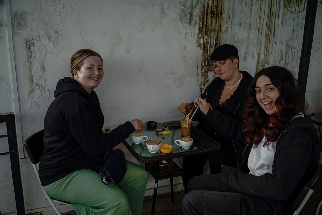 Trois personnes prenant des verres à une table à l'intérieur.