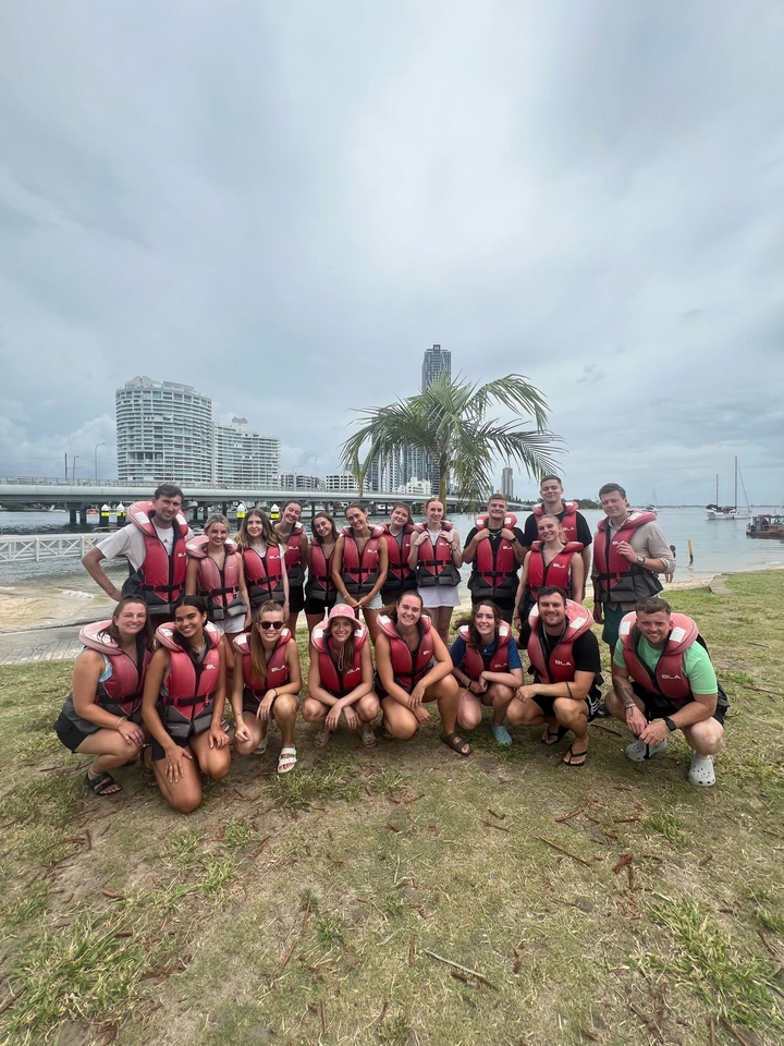 Groupe de personnes en gilets de sauvetage se préparant pour des activités aquatiques.