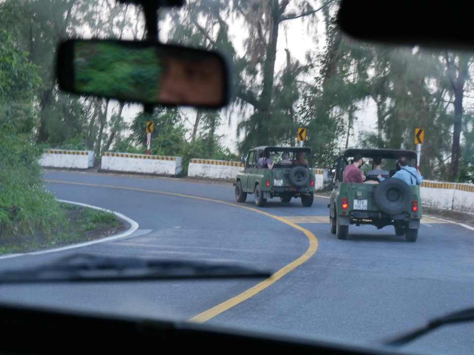 Des gens conduisant des jeeps sur une route sinueuse.