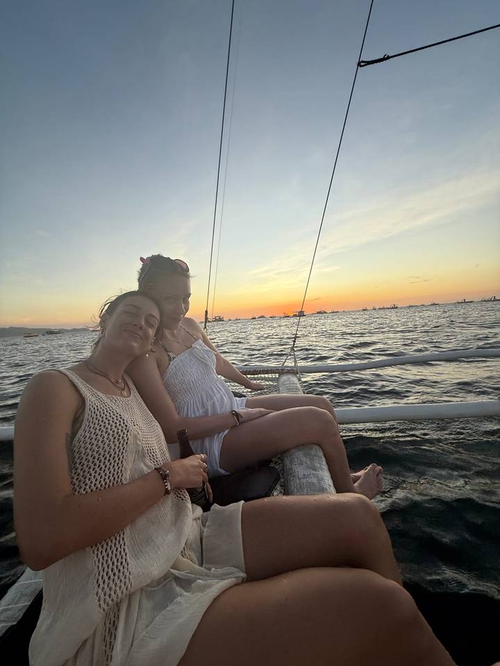 Deux femmes sur un bateau profitant du coucher de soleil.