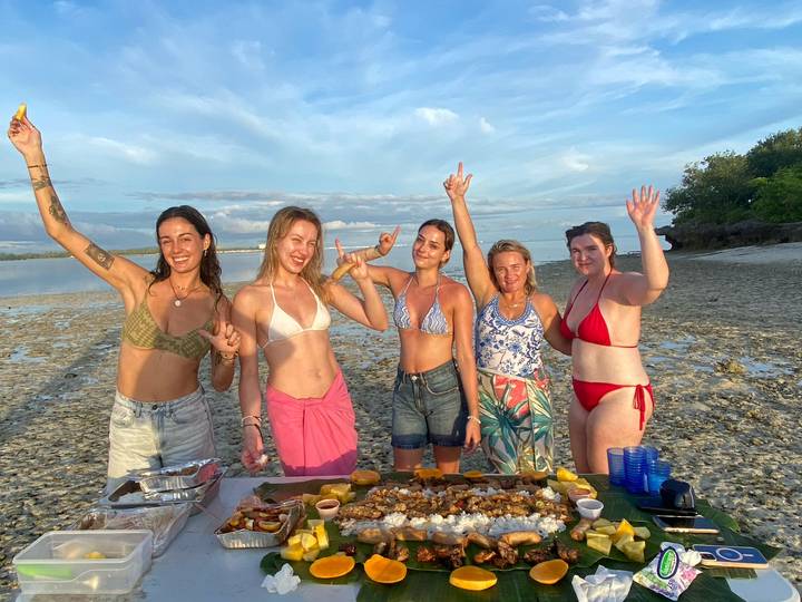 Groupe profitant d'un pique-nique sur la plage avec des fruits de mer.