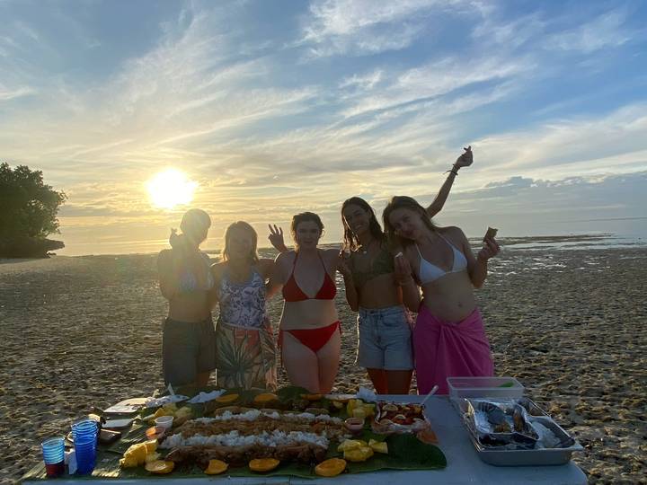 Groupe à une fête de plage avec le coucher de soleil.