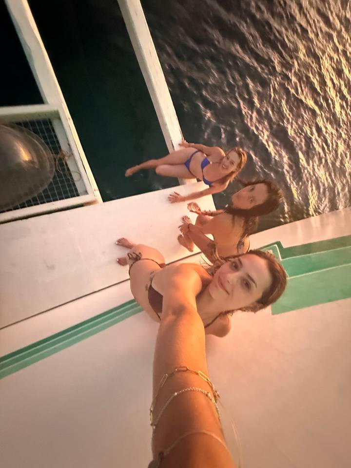 Groupe de femmes sur un bateau prenant un selfie.