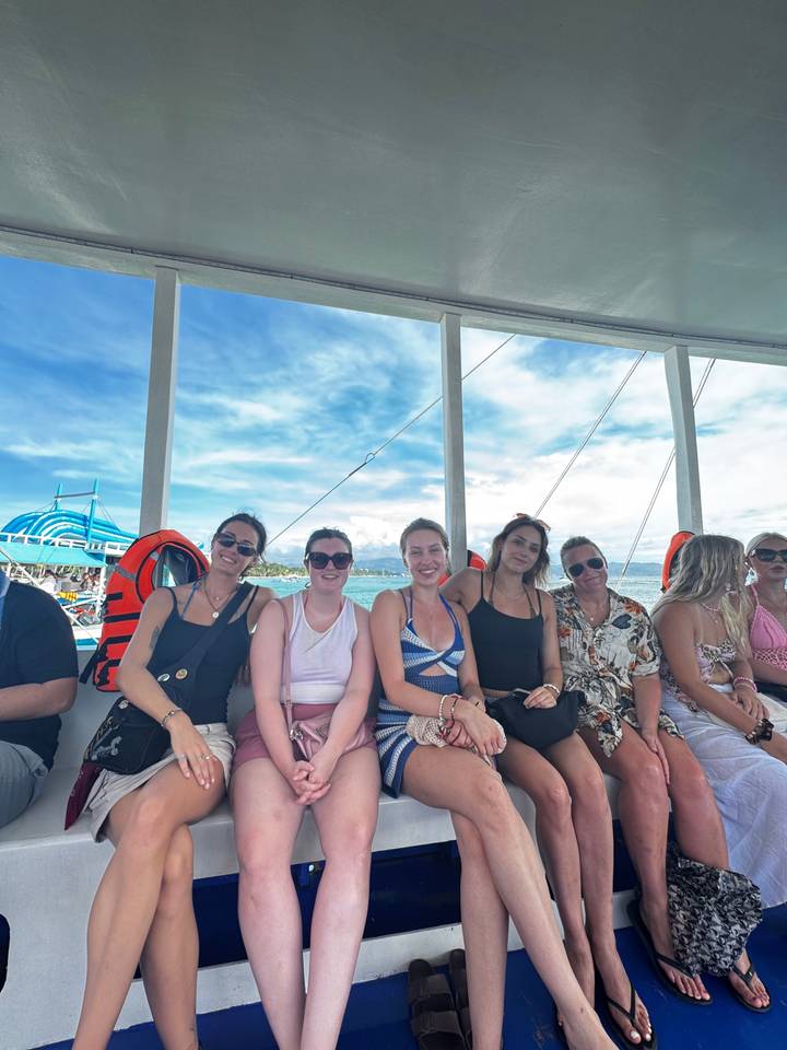 Groupe de personnes sur un bateau avec des gilets de sauvetage.