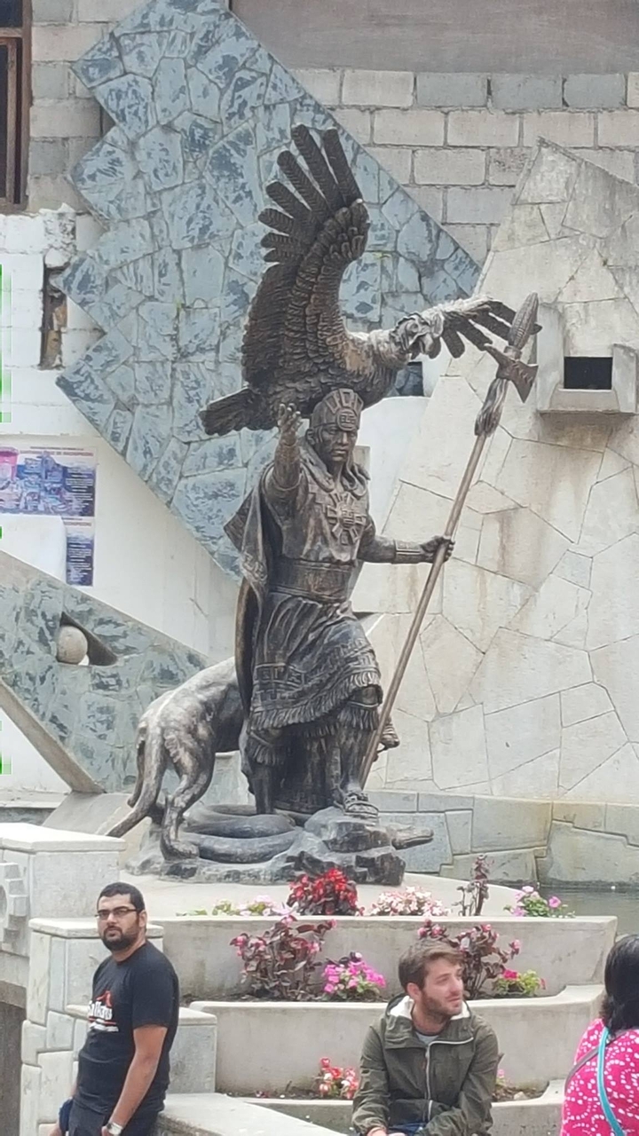 Statue d'un personnage inca tenant un bâton.