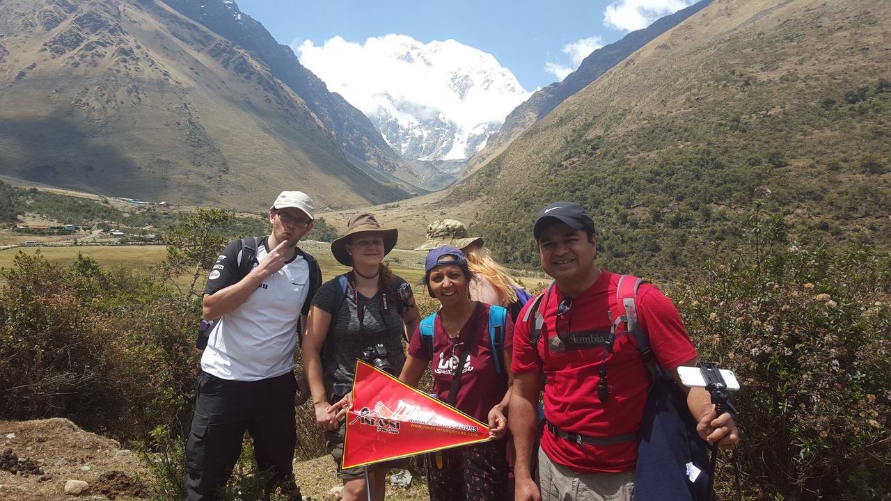 Groupe de randonneurs posant sur fond de montagne.