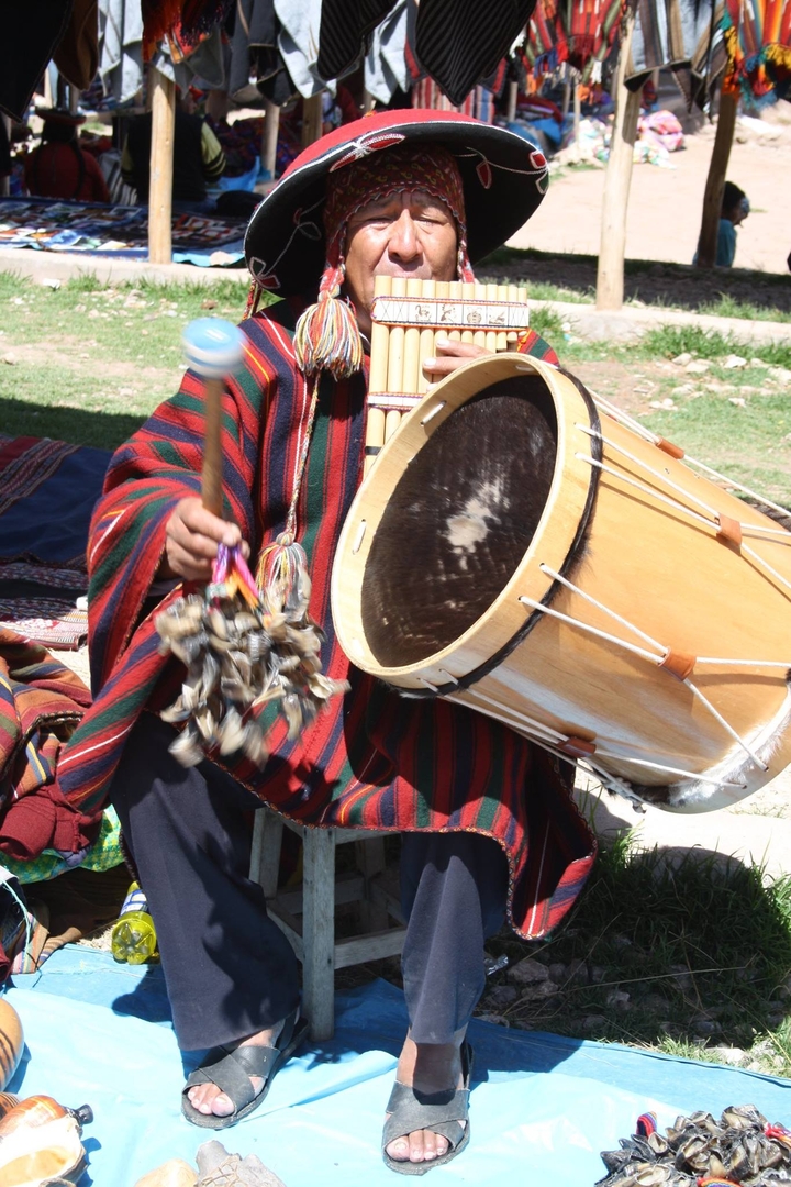 Musicien jouant du tambour en tenue traditionnelle.