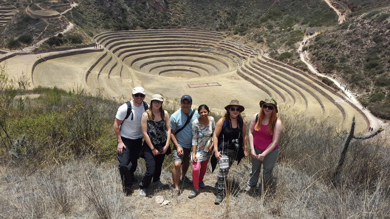 Groupe de personnes sur un site archéologique en terrasses.