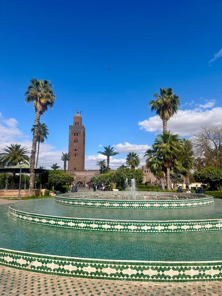 Koutoubia-Moschee mit einem Brunnen und Palmen in Marrakesch.