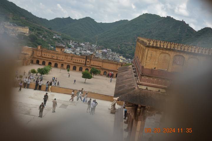 Terrain du fort avec des gens qui marchent et des collines en arrière-plan.