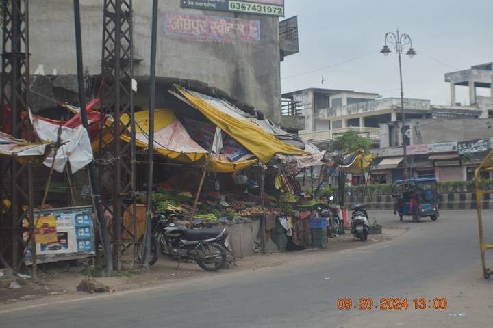 Une scène de rue avec des étals de fortune et des motos.