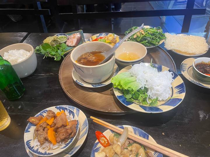 Repas vietnamien traditionnel avec bols et plats.