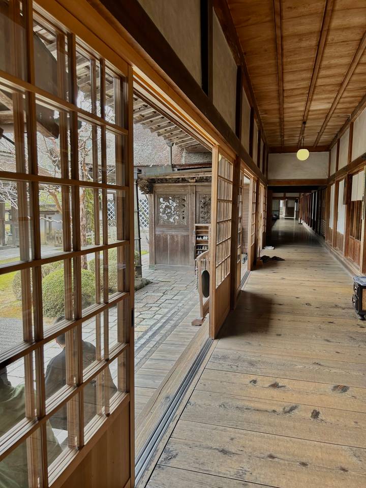 Intérieur d'un bâtiment traditionnel en bois avec des portes coulissantes ouvertes.