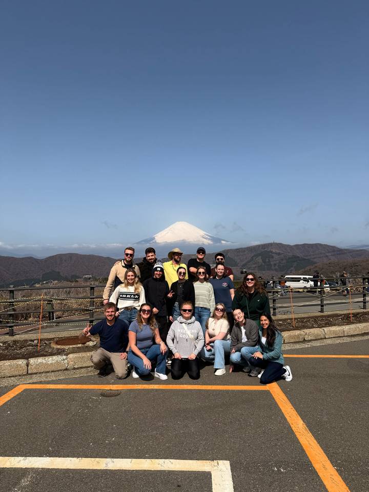 Groupe souriant devant le mont Fuji.