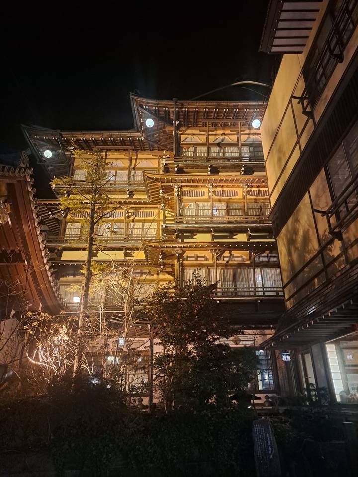 Bâtiment japonais traditionnel éclairé la nuit.