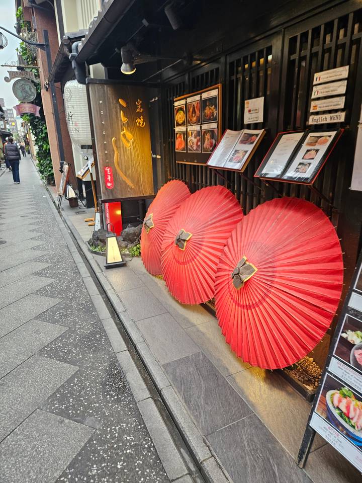 Trois parasols rouges contre un mur.