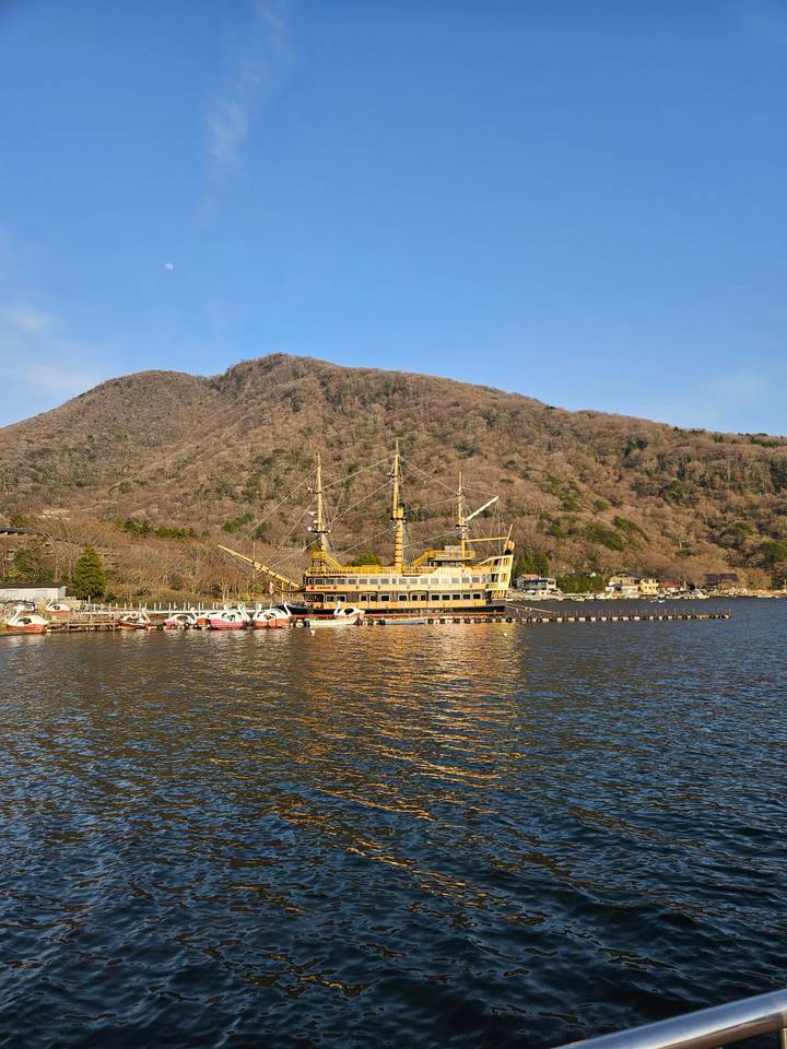 Un navire amarré près d'un lac avec des collines en arrière-plan.