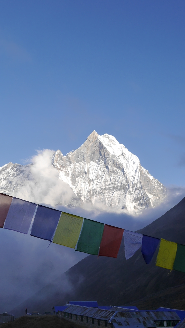 Vue rapprochée d'un pic montagneux enneigé sous un ciel dégagé.