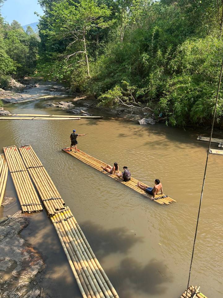 Des gens qui font du radeau sur une rivière avec des radeaux en bambou.
