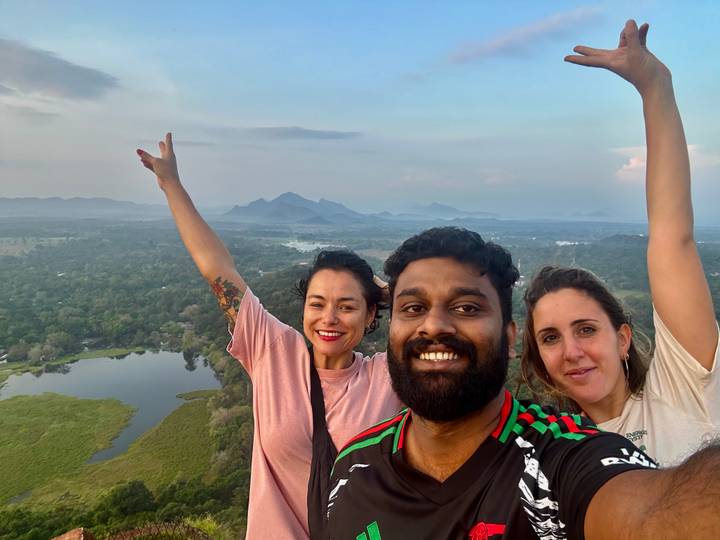 Groupe de personnes prenant un selfie avec un paysage pittoresque en arrière-plan.