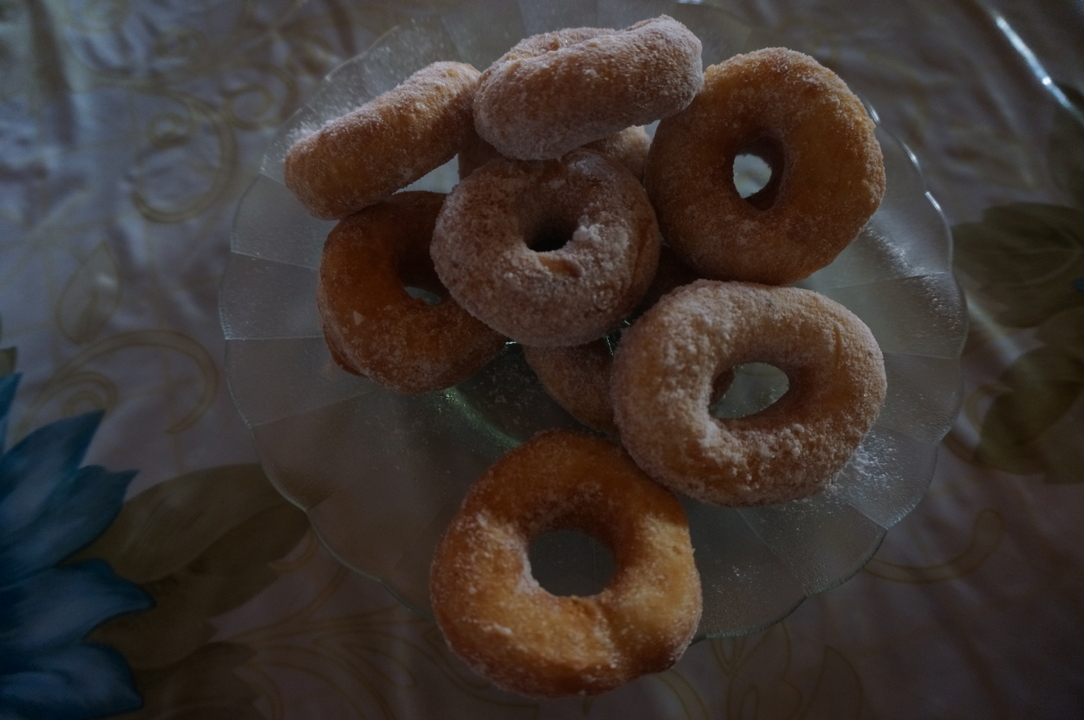 Assiette de beignets sur une nappe à motifs.