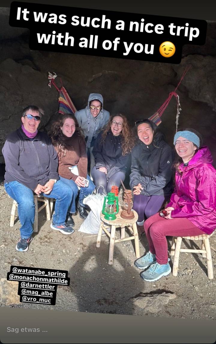 Groupe de personnes assises et souriantes à l'intérieur, avec une décoration rustique.