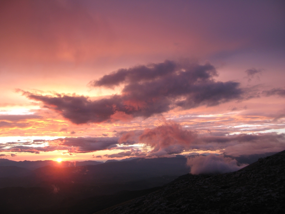 Coucher de soleil coloré avec des nuages spectaculaires au-dessus des montagnes.