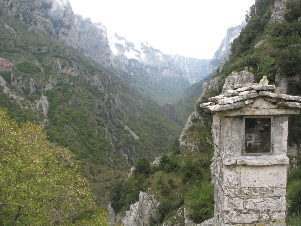 Gorge de montagne étroite avec un petit sanctuaire sur le bord.