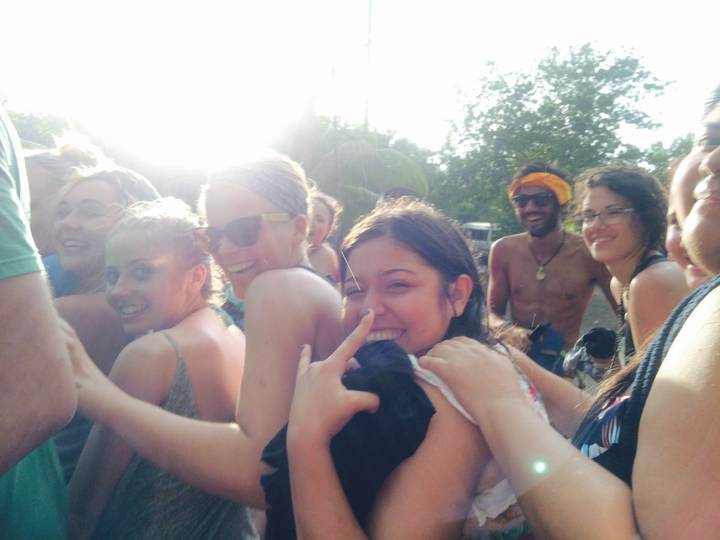 Group of smiling people close together at a sunny location.