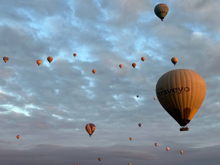 Montgolfières flottant au-dessus de vallées pittoresques au lever du soleil.