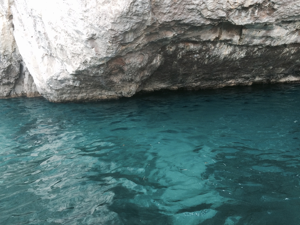 Eau bleue claire près de falaises rocheuses.