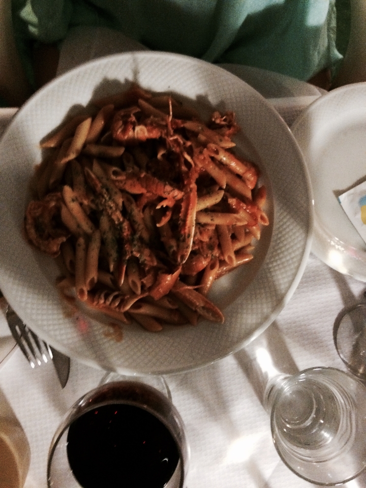 Assiette de pâtes penne aux fruits de mer dans une sauce tomate.