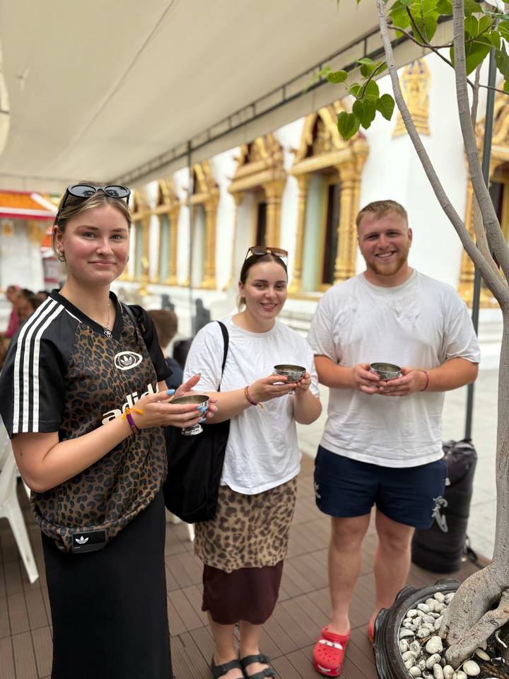 Groupe de personnes tenant des tasses dans une zone de temple.