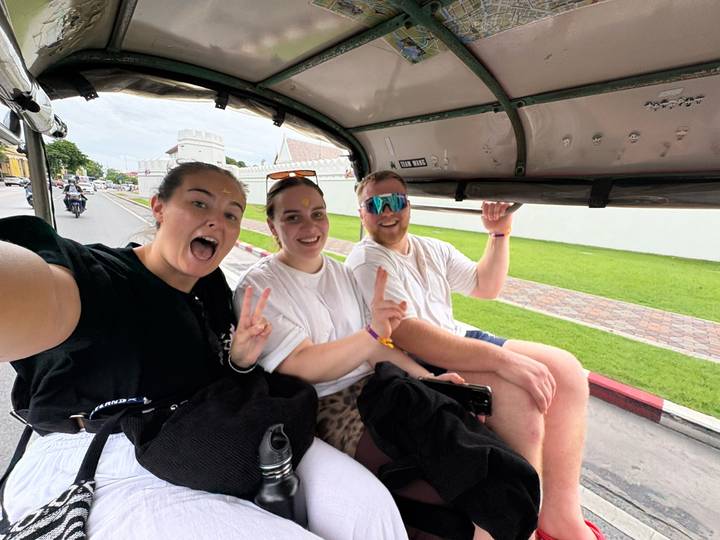 Trois personnes profitant d'un trajet en tuk-tuk.