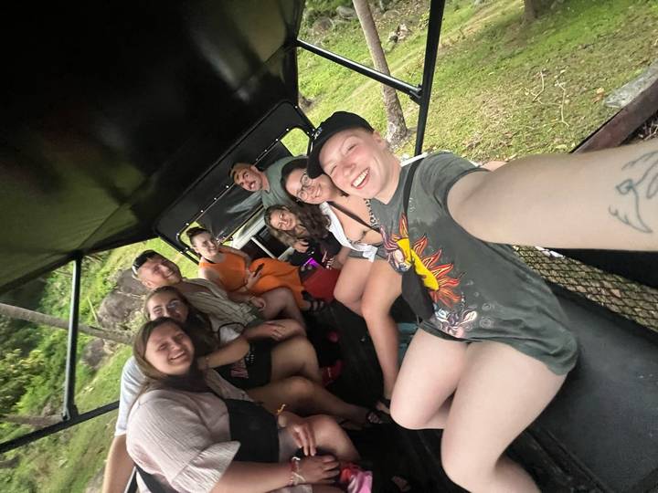 Groupe de personnes à l'intérieur d'un véhicule, souriant pour un selfie.