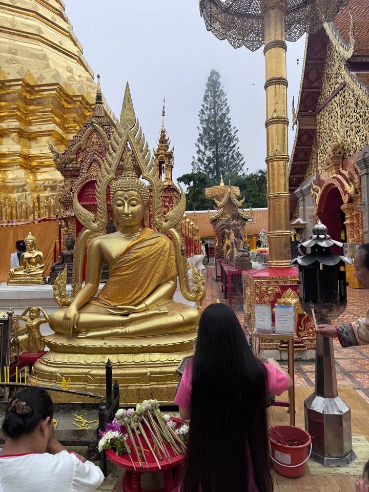 Statue de Bouddha doré dans une cour de temple.