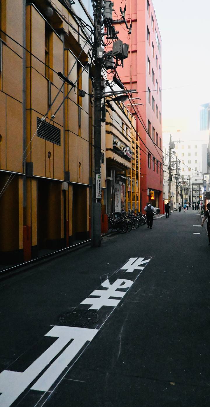 Vue de rue avec des vélos et des bâtiments, une personne qui marche.