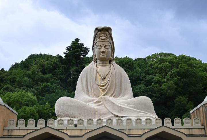 Gros plan d'une grande statue de Bouddha dans un parc.