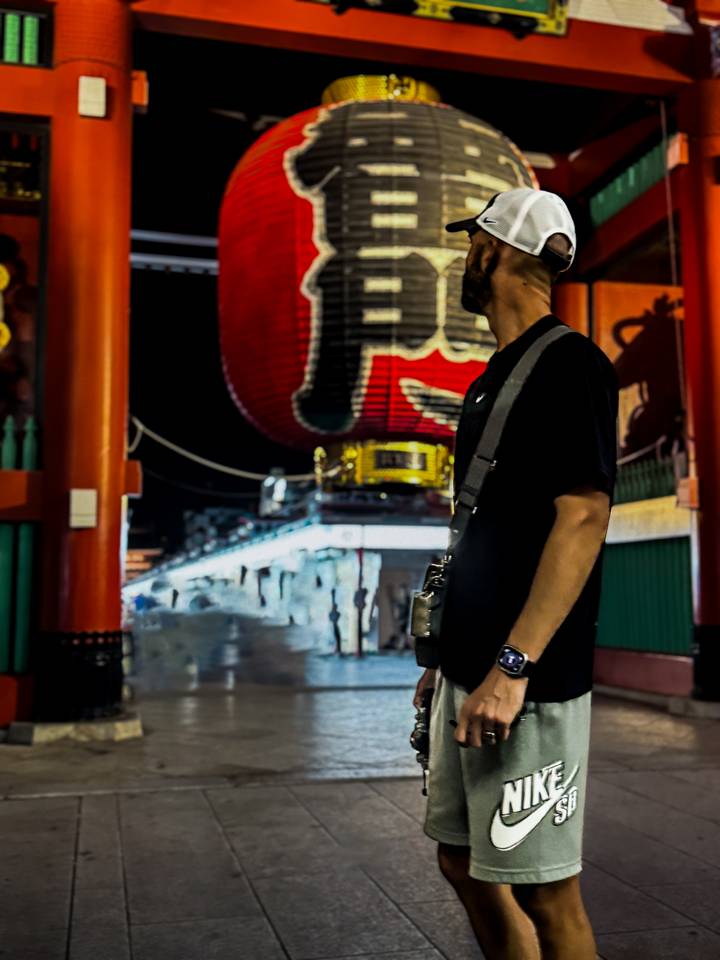 Personne à côté d'une grande lanterne rouge la nuit.